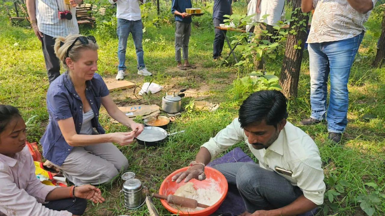 Guests learning to make rotis on an open fire with a local cook